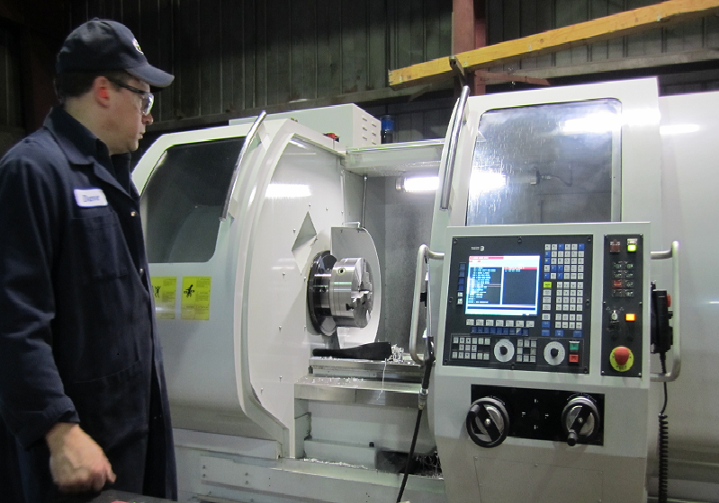 Machinist checking a computer-controlled lathe