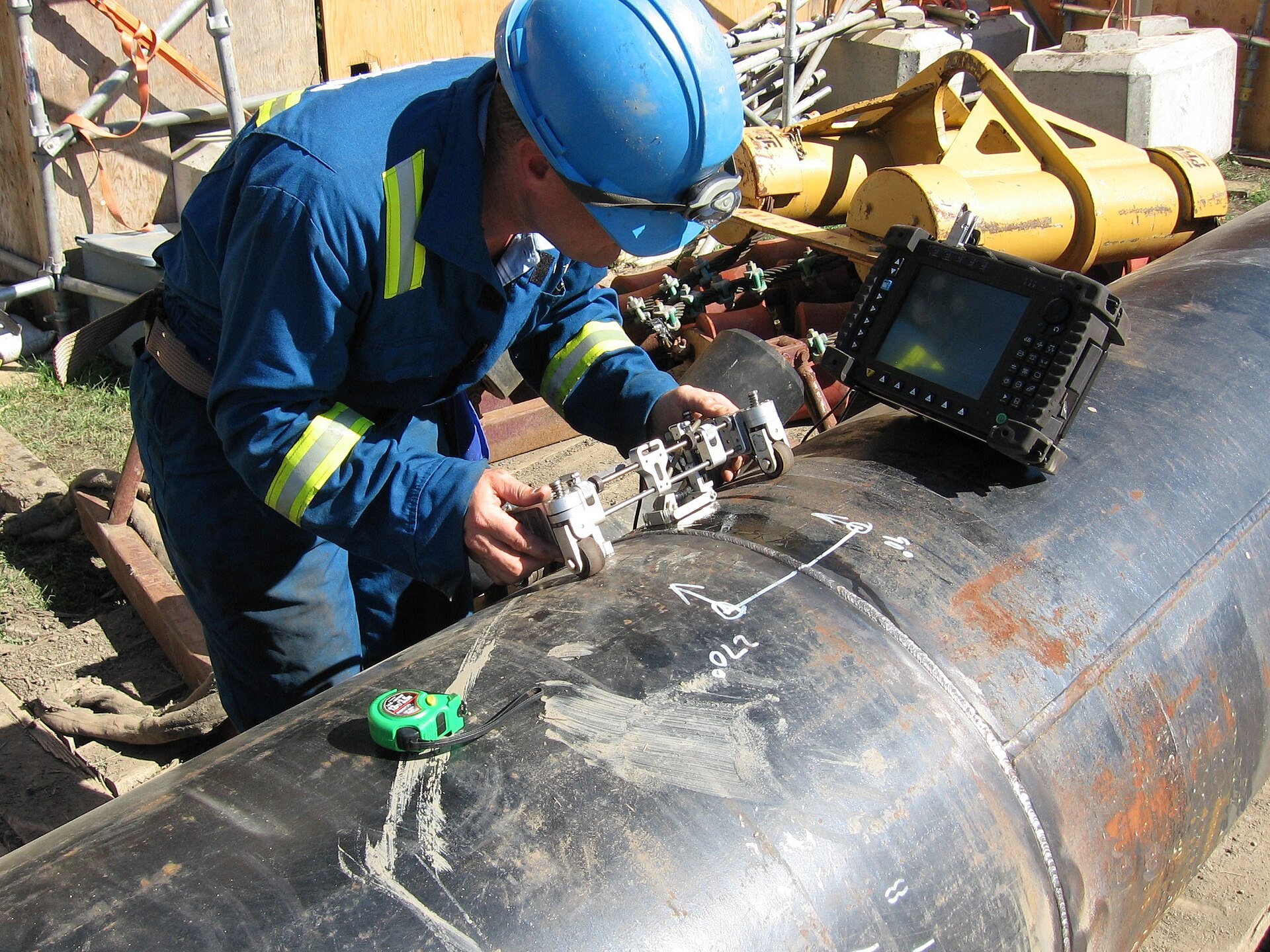 Technician carrying out ultrasonic examination on metal equipment